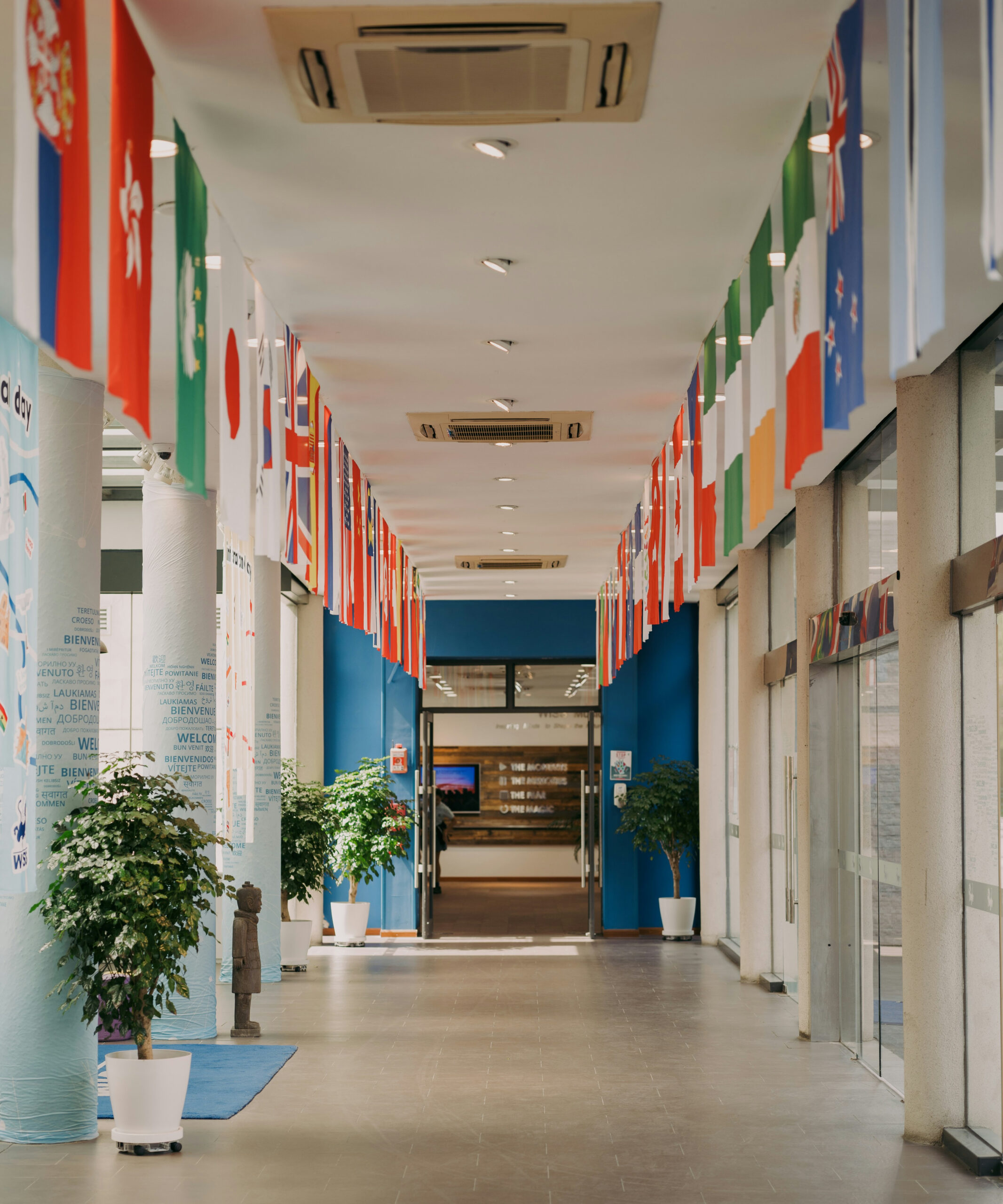 Schuleingang internationaler Schule mit Flaggen verschiedener Länder – Symbol für deutschsprachige Nachhilfe an internationalen Schulen weltweit